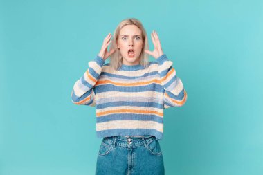 Sarışın, güzel bir kadın elleri havada çığlık atıyor.