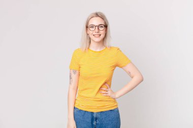 Sarışın, güzel bir kadın mutlu bir şekilde gülümsüyor.