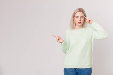 Sarışın, güzel bir kadın. Kafası karışık ve şaşkın. Deli olduğunu gösteriyor.