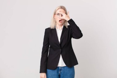 Sarışın, güzel bir kadın şok olmuş, korkmuş ya da korkmuş görünüyor. Yüzü elle kapatılmış. iş kavramı