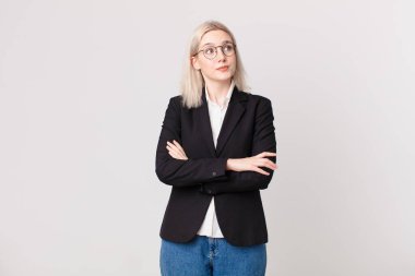 Sarışın, güzel bir kadın omuz silkiyor, kafası karışık ve kararsız. iş kavramı