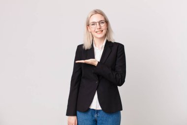 Sarışın, güzel bir kadın, neşeli bir şekilde gülümsüyor, mutlu hissediyor ve bir konsept gösteriyor. iş kavramı