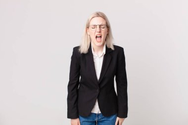 Sarışın, güzel bir kadın agresif bir şekilde bağırıyor, çok kızgın görünüyor. iş kavramı