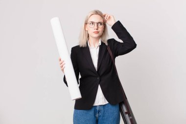 Kafası karışmış, kafası karışmış, kaşınan güzel sarışın bir kadın. mimar konsepti