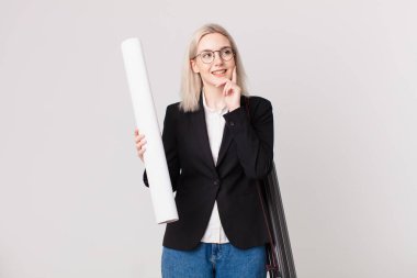 Sarışın, güzel bir kadın mutlu bir şekilde gülümsüyor ve hayal kuruyor ya da şüphe ediyor. mimar konsepti