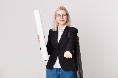 Sarışın, güzel bir kadın arkadaşça gülümsüyor ve bir konsept sunuyor. mimar konsepti