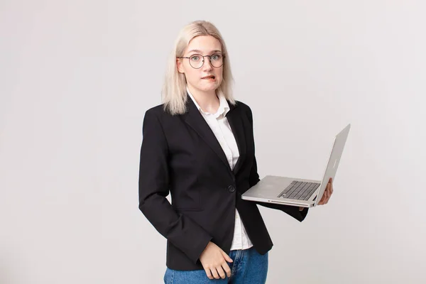 Blondynka Ładna Kobieta Patrząc Zagadkowy Zdezorientowany Trzymając Laptop — Zdjęcie stockowe