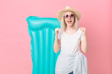 Sarışın, güzel bir kadın şoke olmuş, gülüyor ve başarıyı kutluyor. yaz konsepti