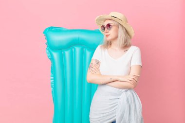 Sarışın, güzel bir kadın omuz silkiyor, kafası karışık ve kararsız. yaz konsepti