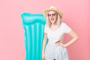 Sarışın, güzel bir kadın agresif bir şekilde bağırıyor, çok kızgın görünüyor. yaz konsepti