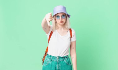 Sarışın, güzel bir kadın. Huysuz hissediyor, baş parmağını kaldırıyor. yaz konsepti