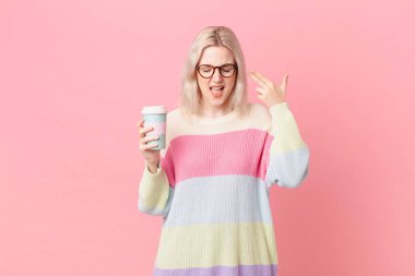 blond pretty woman looking unhappy and stressed, suicide gesture making gun sign. coffee concept