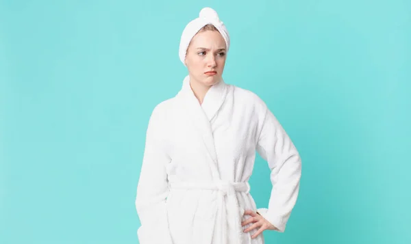 blond pretty woman feeling sad, upset or angry and looking to the side and wearing bathrobe