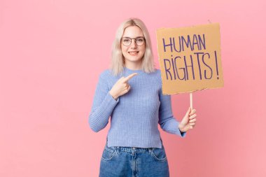 blond woman protesting with a cardboard banner