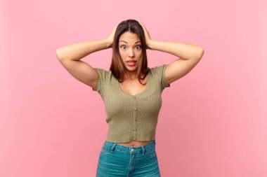 Genç İspanyol kadın stresli, endişeli ya da korkmuş hissediyor, elleri başının üstünde.