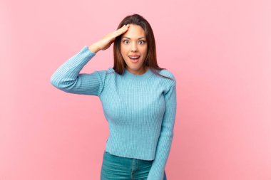 Genç İspanyol kadın mutlu, şaşkın ve şaşkın görünüyor.