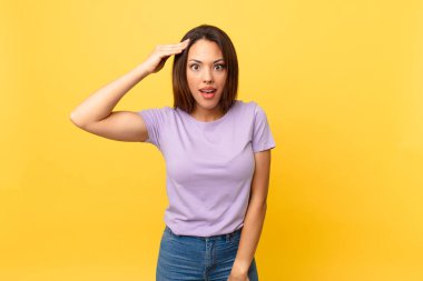 Genç İspanyol kadın mutlu, şaşkın ve şaşkın görünüyor.