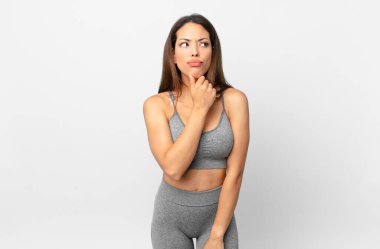 Genç İspanyol kadın düşünüyor, kuşkulu ve şaşkın hissediyor. fitness konsepti