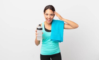 Genç İspanyol kadın mutlu, şaşkın ve şaşırmış görünüyor. fitness konsepti