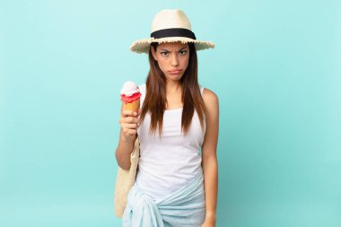 Genç İspanyol kadın üzgün ve mızmızlanıyor. Mutsuz bir bakışı var. Ağlıyor ve elinde dondurma tutuyor. sumer kavramı