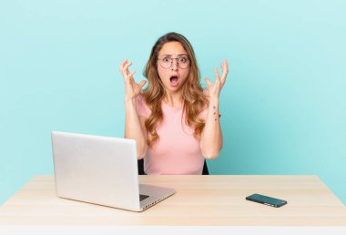 Güzel bir kadın ellerini havaya kaldırarak çığlık atıyor. telework konsepti