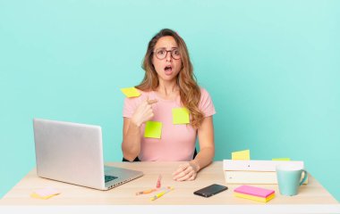 Şok olmuş ve ağzı açık, kendini gösteren güzel bir kadın. telework konsepti