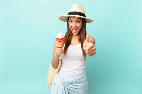 年轻的惊慌失措的女人感到自豪 竖起大拇指 拿着冰淇淋 面带微笑 更简单的概念 — 图库照片