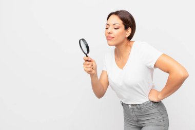 Genç İspanyol kadın elinde büyüteç tutuyor.