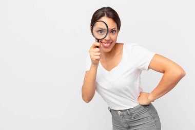 Genç İspanyol kadın elinde büyüteç tutuyor.