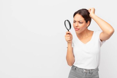 Genç İspanyol kadın elinde büyüteç tutuyor.