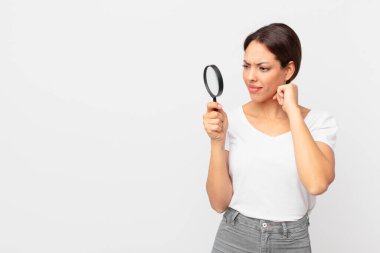 Genç İspanyol kadın elinde büyüteç tutuyor.