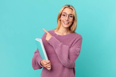 Kitapları tutan sarışın, güzel bir kadın. öğrenci konsepti