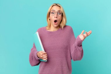 Kitapları tutan sarışın, güzel bir kadın. öğrenci konsepti