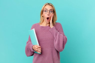 Kitapları tutan sarışın, güzel bir kadın. öğrenci konsepti