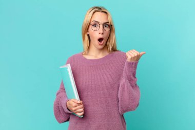 Kitapları tutan sarışın, güzel bir kadın. öğrenci konsepti