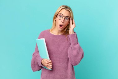 Kitapları tutan sarışın, güzel bir kadın. öğrenci konsepti