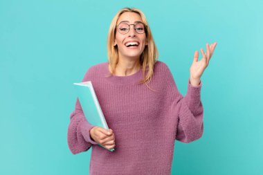 Kitapları tutan sarışın, güzel bir kadın. öğrenci konsepti