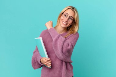 Kitapları tutan sarışın, güzel bir kadın. öğrenci konsepti