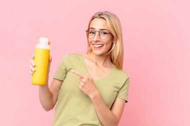 Sarışın, güzel bir kadın portakal suyu içiyor.