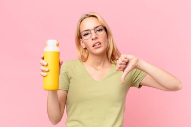 Sarışın, güzel bir kadın portakal suyu içiyor.