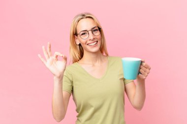 Sarışın, güzel kadın kahve içiyor.