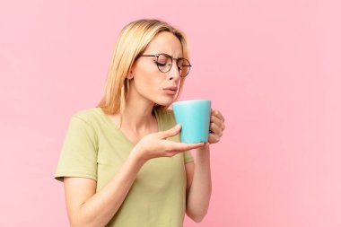 Sarışın, güzel kadın kahve içiyor.