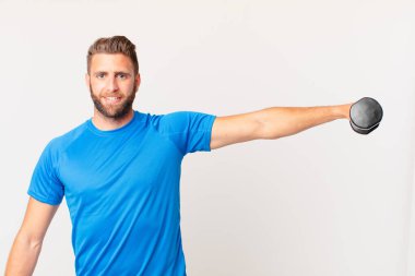 Genç fitness adamı dambılı kaldırıyor.