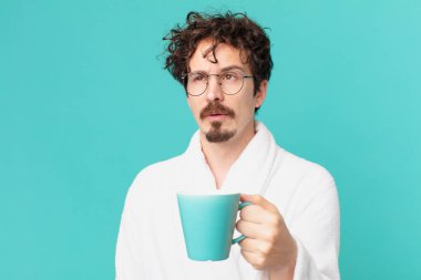 Genç çılgın adam kahve içiyor.