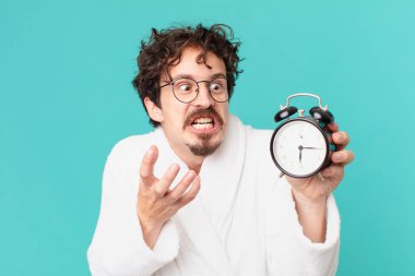 Çalar saati olan genç deli bir adam.