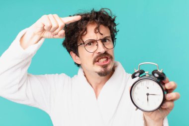 Çalar saati olan genç deli bir adam.