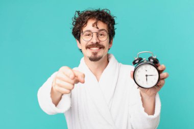 Çalar saati olan genç deli bir adam.