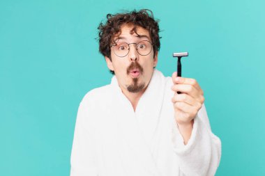 Delikanlı sakalını jiletle tıraş ediyor.