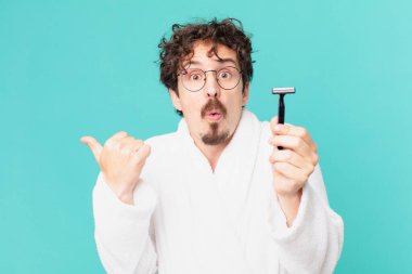 Delikanlı sakalını jiletle tıraş ediyor.