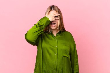 Kıvrımlı, güzel, sarışın kadın. Şok olmuş, korkmuş ya da korkmuş görünüyor.